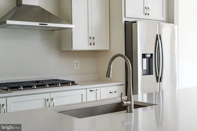 a kitchen with white cabinets and black appliances