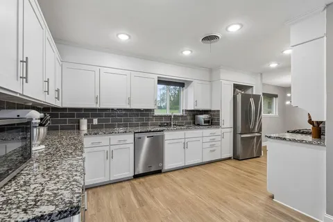 a kitchen with a refrigerator stove top oven and sink
