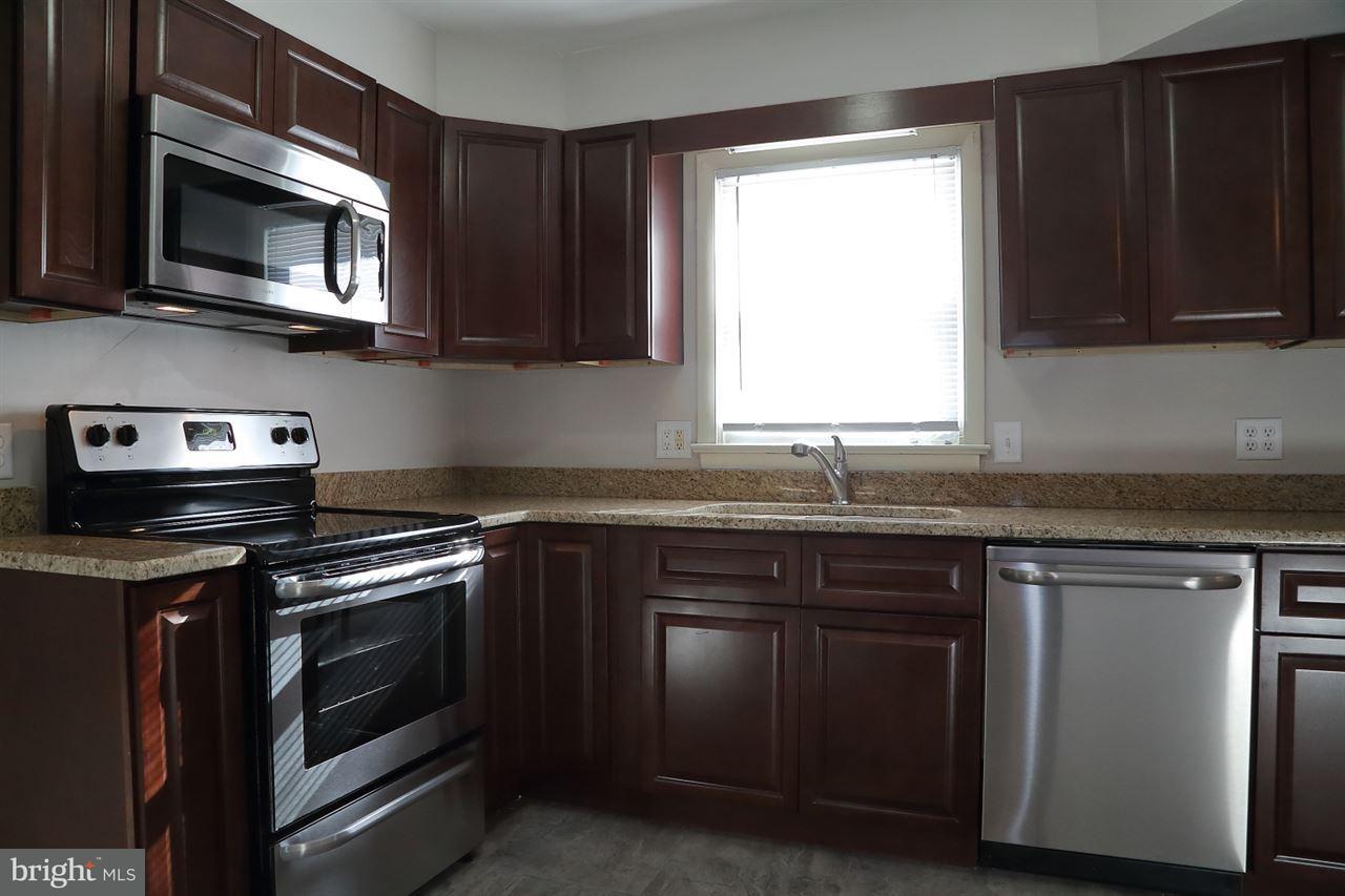924 Hanover Road York, PA 17408 - Photo 5 of 20 a kitchen with stainless steel appliances granite countertop wooden cabinets stove top oven and sink