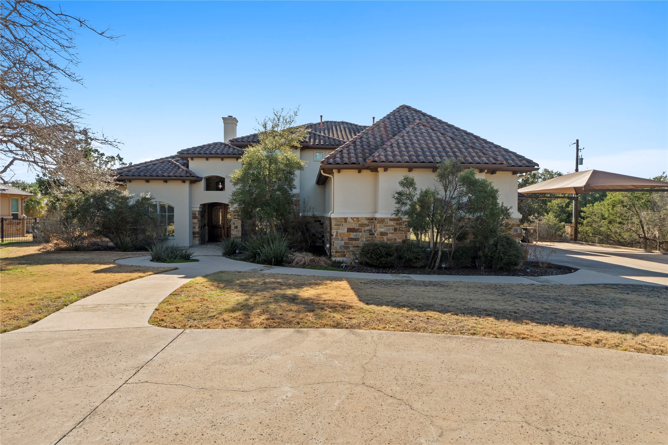 Stone and stucco home with concrete tile roof. Circle driveway adds convenients and lots of parking