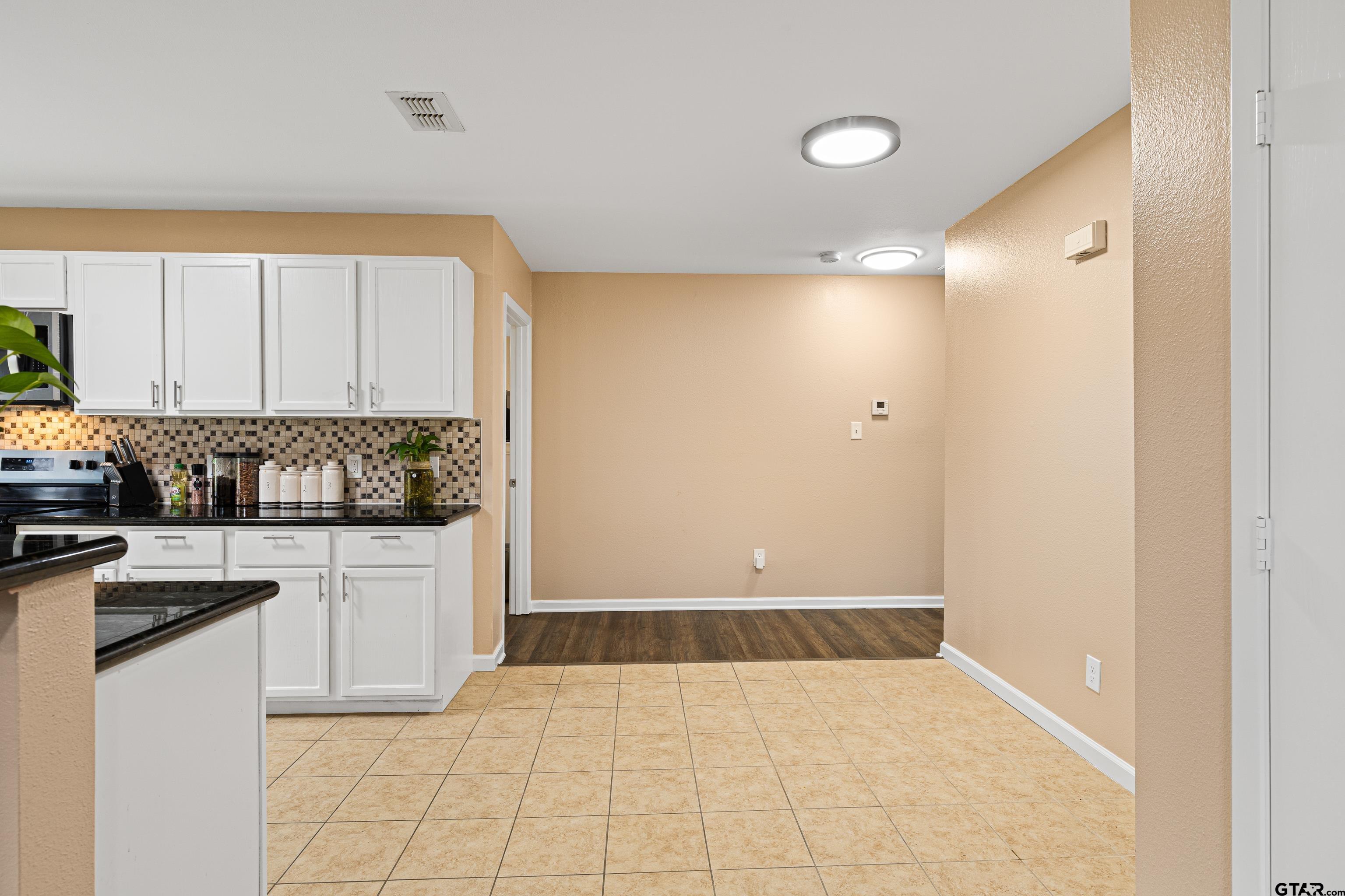 553 Princess Place Tyler, TX 75704 - Photo 18 of 32 a kitchen with granite countertop a refrigerator sink and cabinets