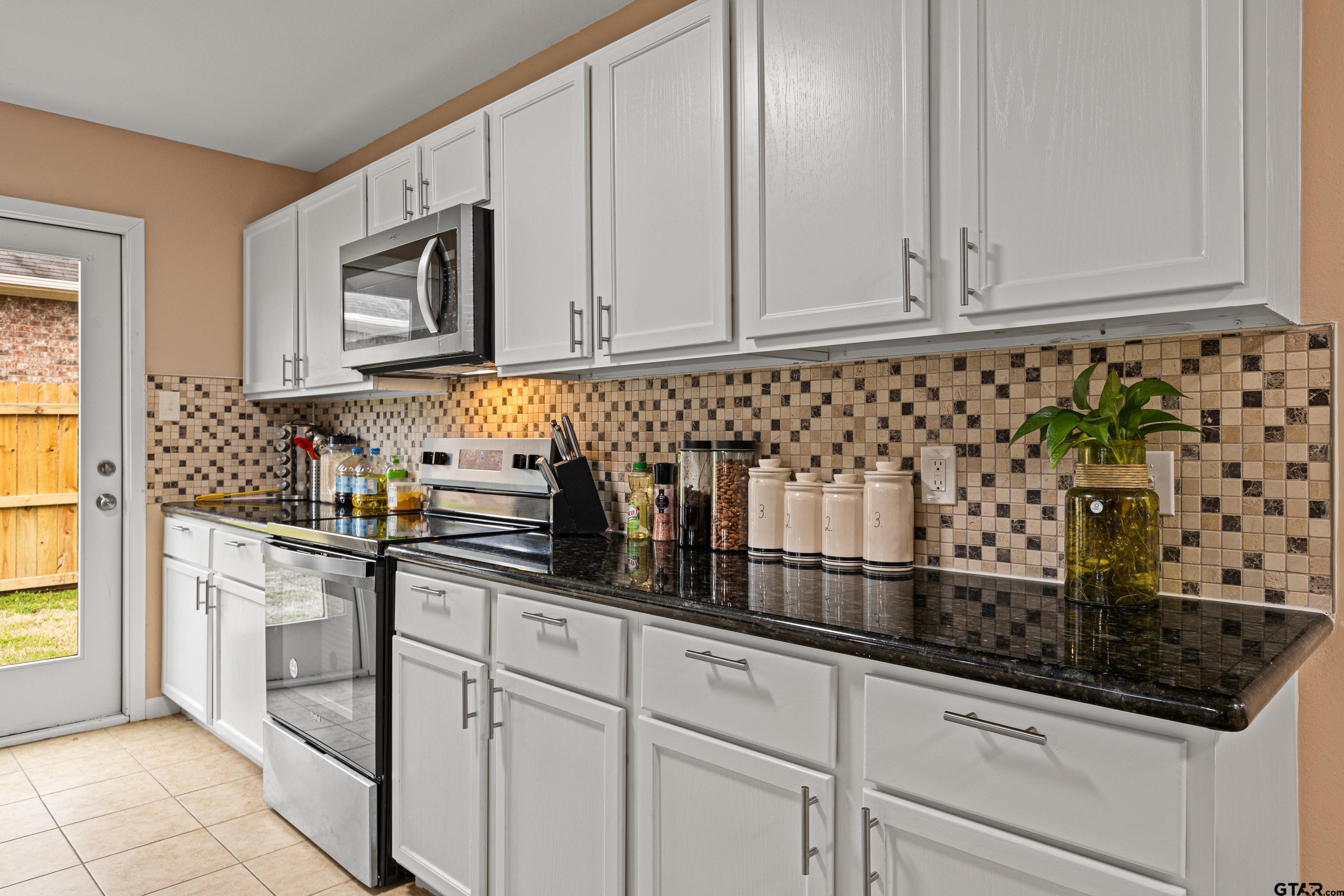 553 Princess Place Tyler, TX 75704 - Photo 26 of 32 a kitchen with stainless steel appliances granite countertop white cabinets and a sink