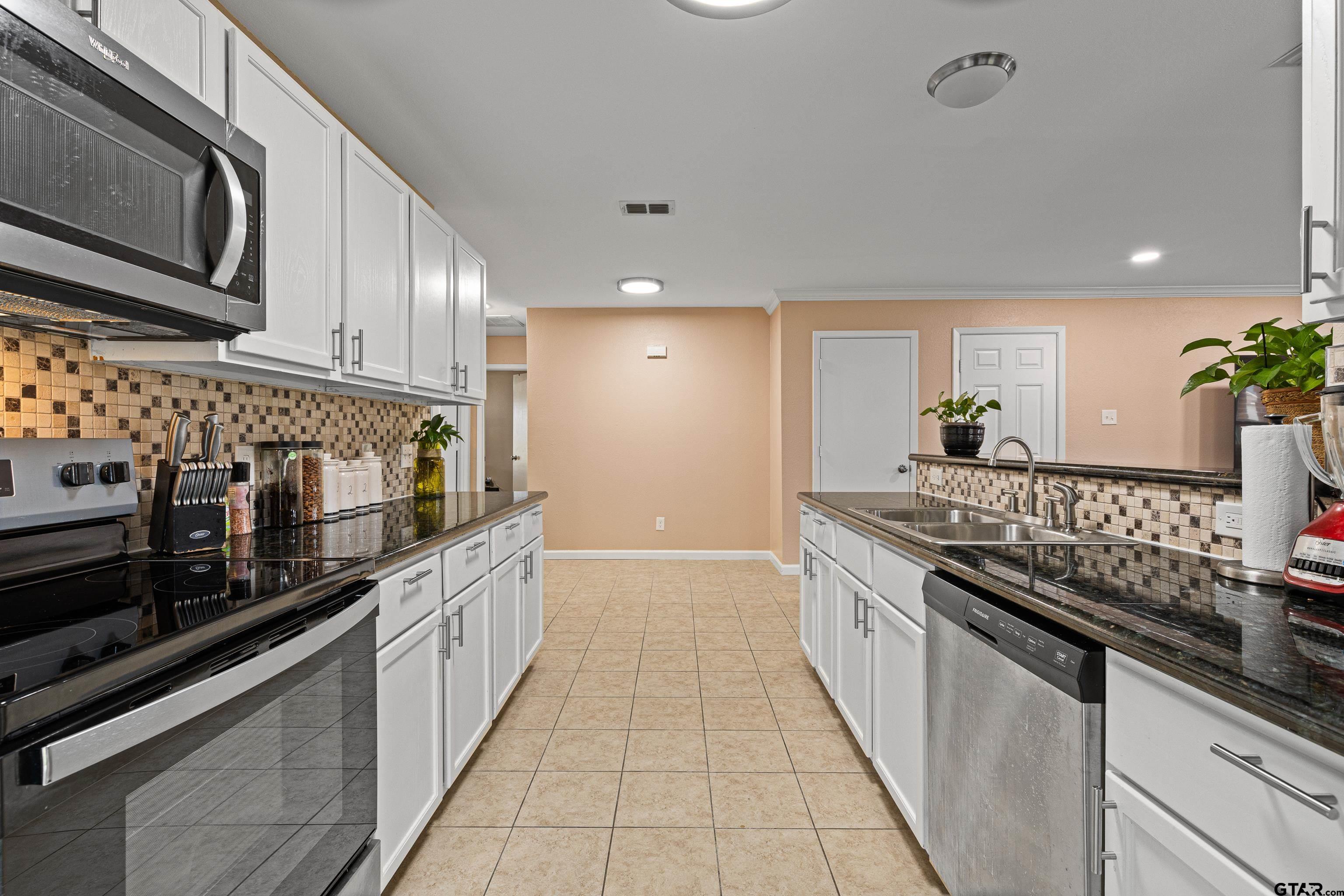 553 Princess Place Tyler, TX 75704 - Photo 27 of 32 a large kitchen with stainless steel appliances granite countertop a stove and a sink