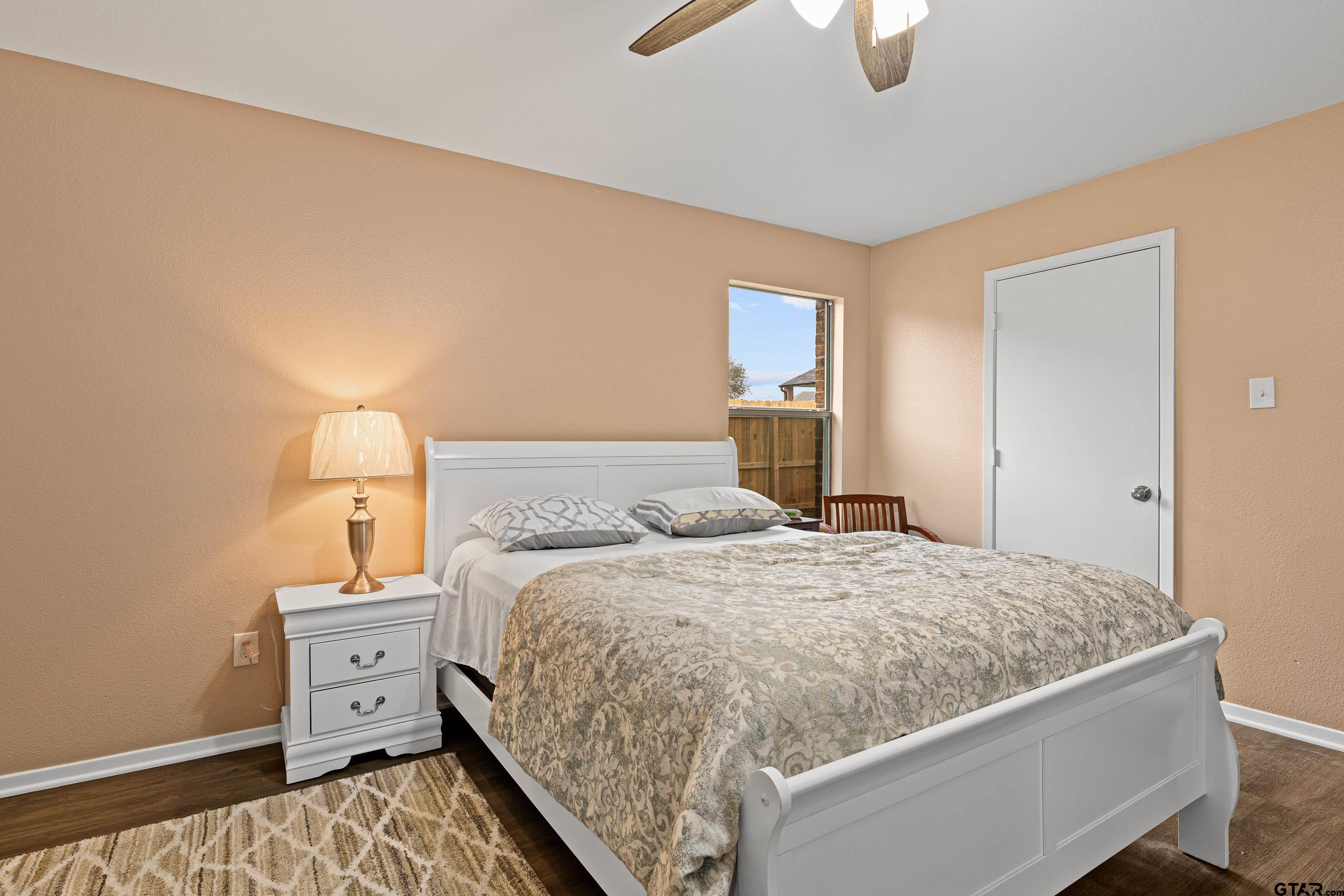 553 Princess Place Tyler, TX 75704 - Photo 29 of 32 a bedroom with a bed and lamp