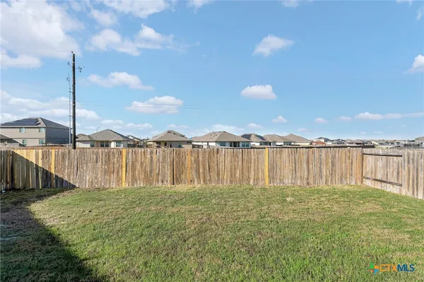 a backyard of a house with wooden fence