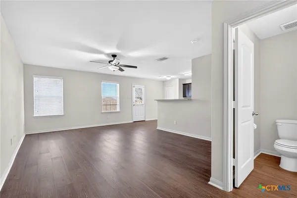 a view of a livingroom with wooden floor and a ceiling fan