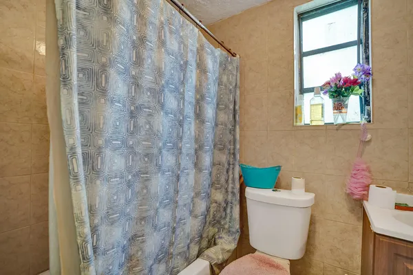 a bathroom with a toilet and a shower curtain