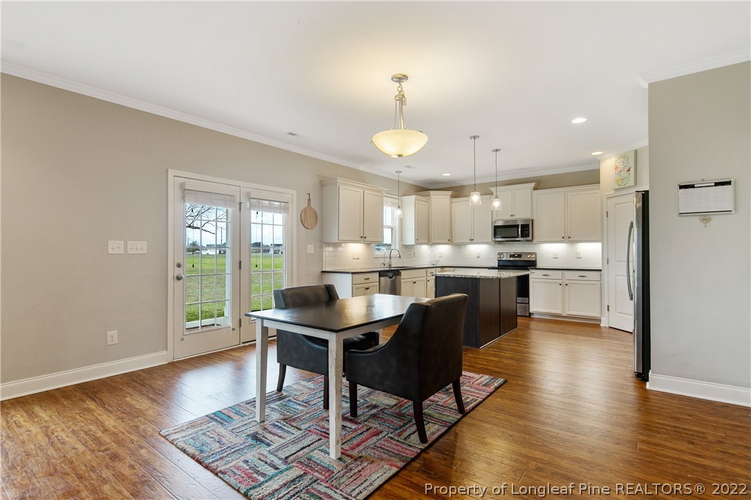 5213 Bree Bridge Road Hope Mills, NC 28348 - Photo 16 of 50 a kitchen with stainless steel appliances kitchen island granite countertop a sink and cabinets
