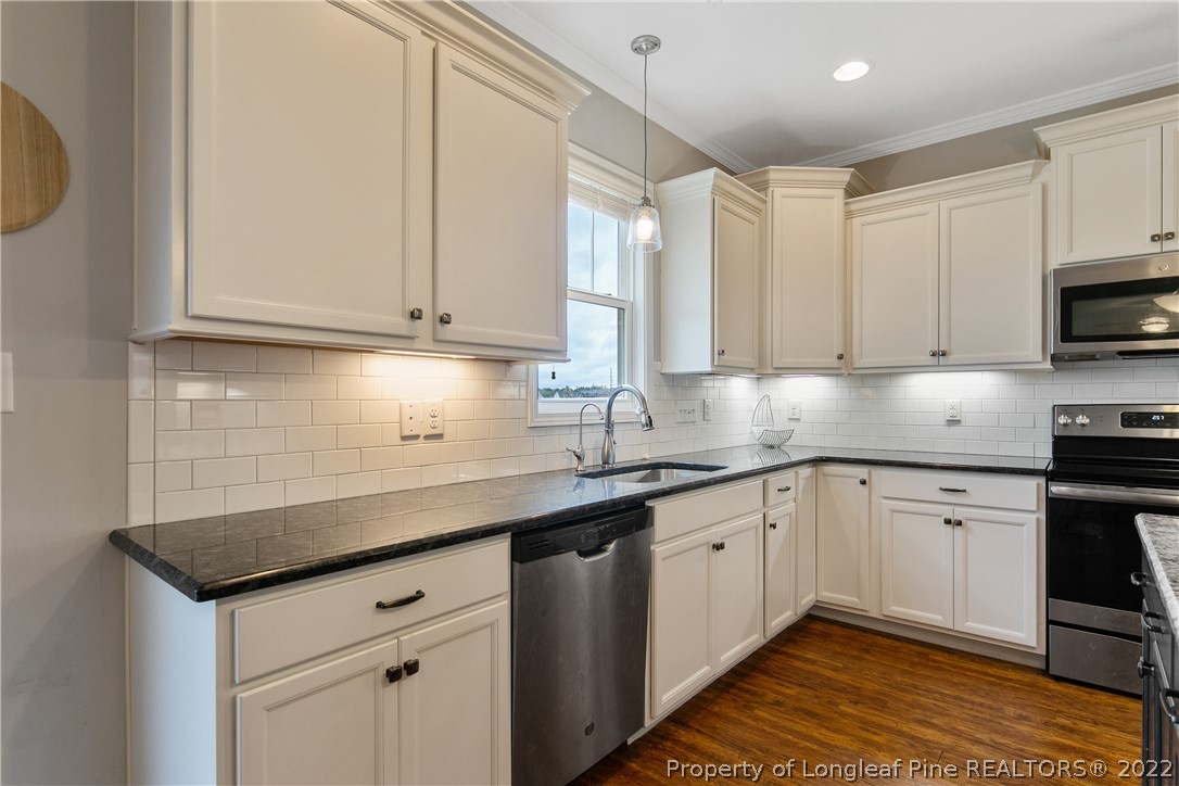 5213 Bree Bridge Road Hope Mills, NC 28348 - Photo 18 of 50 a kitchen with stainless steel appliances granite countertop a sink a stove and a microwave