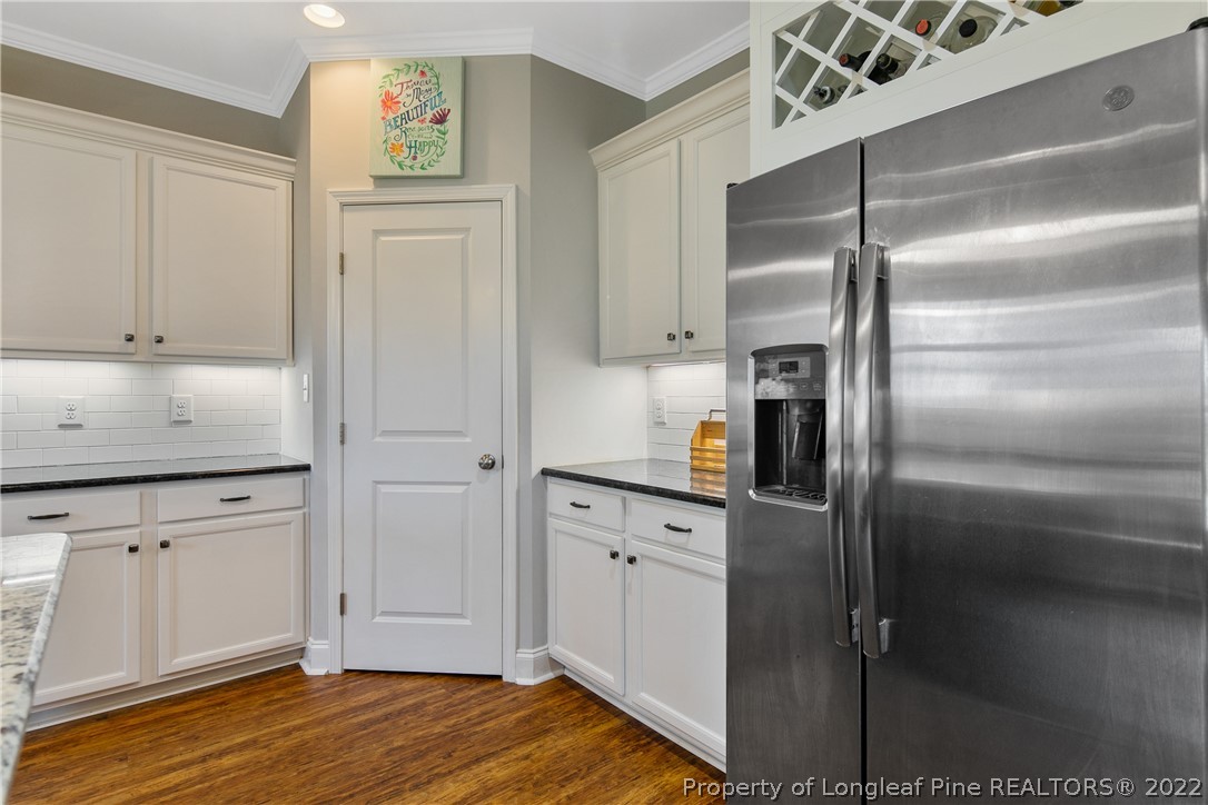 5213 Bree Bridge Road Hope Mills, NC 28348 - Photo 20 of 50 a kitchen with stainless steel appliances cabinets and a wooden floor