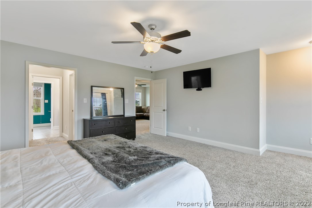 5213 Bree Bridge Road Hope Mills, NC 28348 - Photo 29 of 50 a bedroom with a large bed and a chandelier