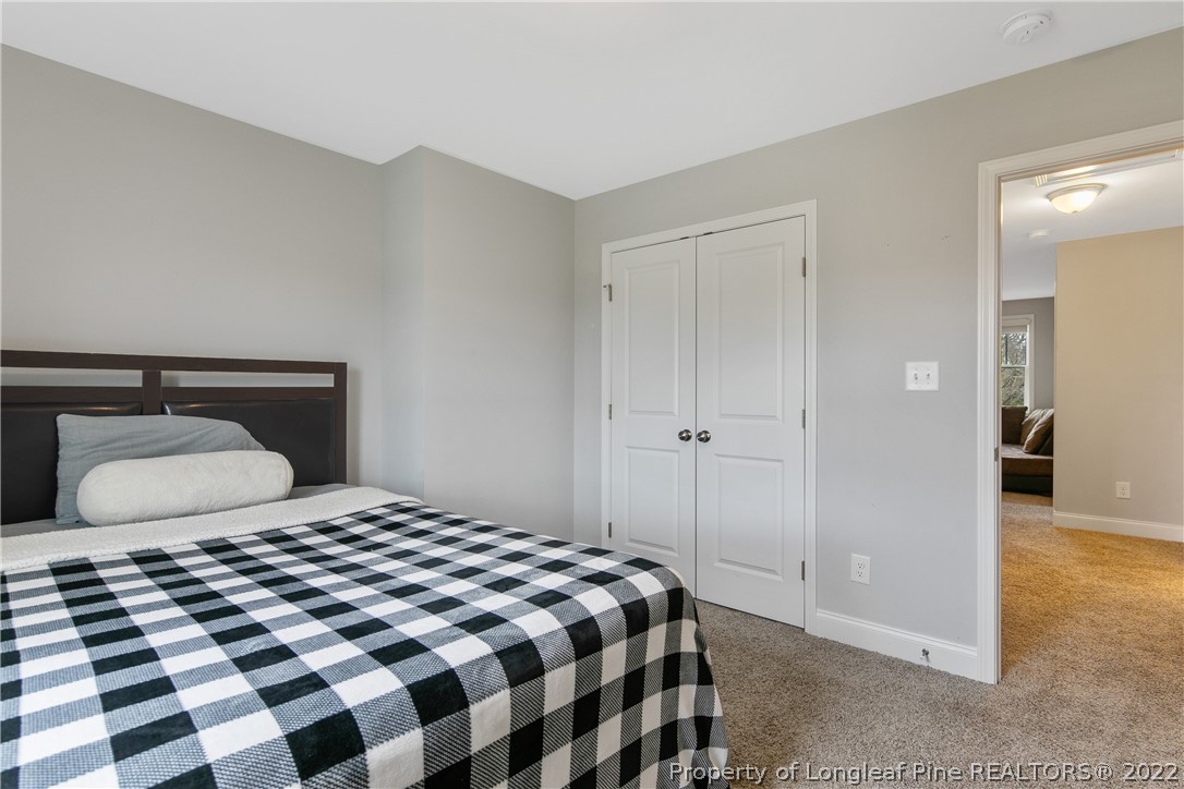 5213 Bree Bridge Road Hope Mills, NC 28348 - Photo 46 of 50 a bedroom with a large bed and a mirror