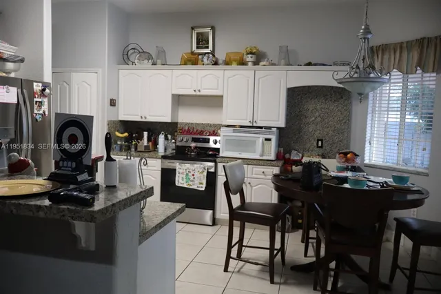 a kitchen with kitchen island granite countertop a sink appliances and cabinets