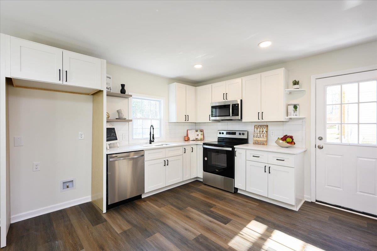 5506 McCormick Road Durham, NC 27713 - Photo 13 of 28 a kitchen with granite countertop white cabinets and white appliances