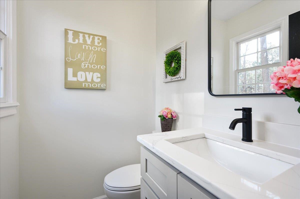 5506 McCormick Road Durham, NC 27713 - Photo 25 of 28 a bathroom with a toilet sink and mirror