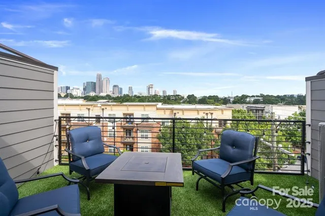 a view of a chairs and table in patio next to a yard
