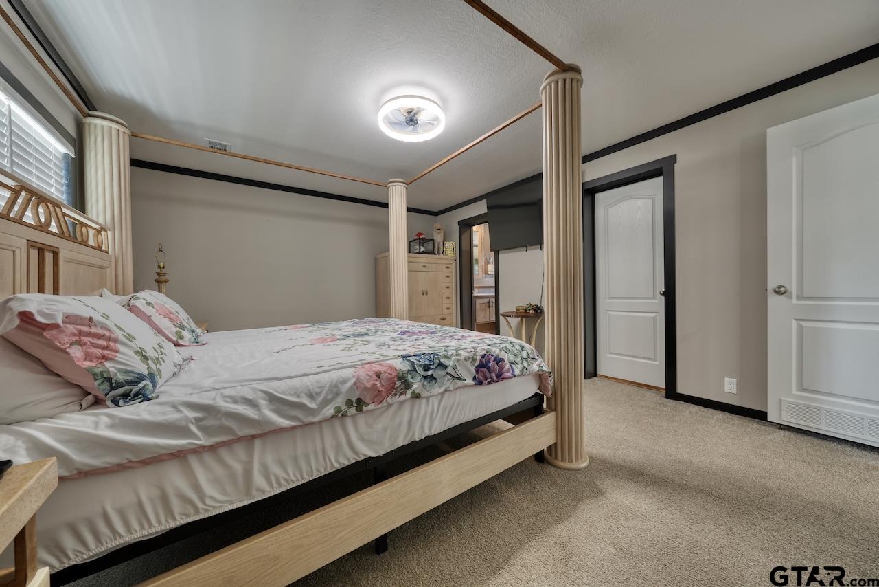 17675 Pine Drive Lindale, TX 75771 - Photo 18 of 35 a bedroom with a bed and a refrigerator