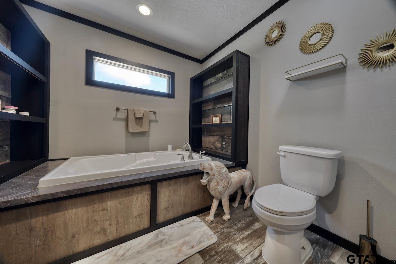 17675 Pine Drive Lindale, TX 75771 - Photo 20 of 35 a bathroom with a granite countertop toilet sink and mirror