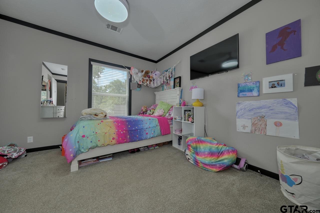 17675 Pine Drive Lindale, TX 75771 - Photo 24 of 35 a bedroom with furniture and a flat screen tv