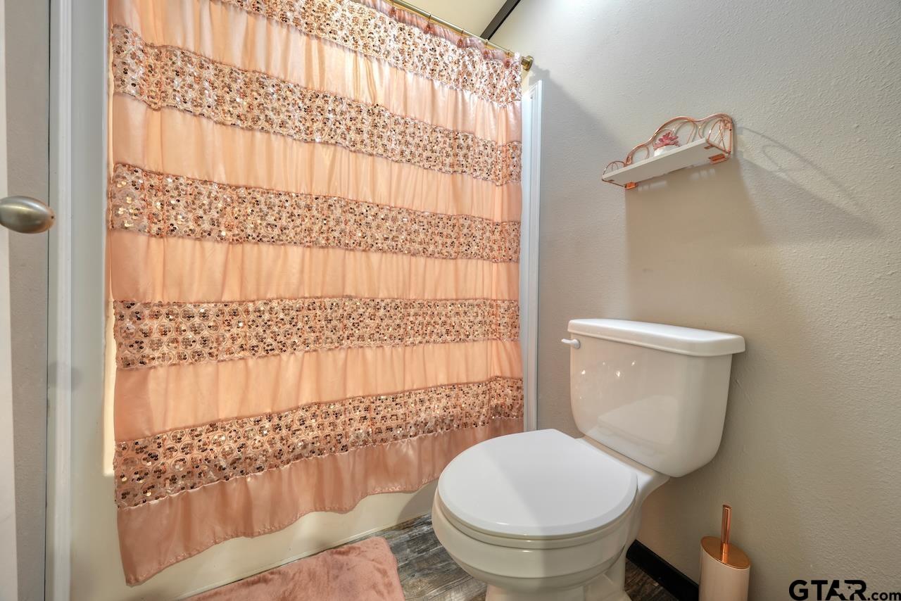 17675 Pine Drive Lindale, TX 75771 - Photo 27 of 35 a bathroom with a toilet and a shower curtain