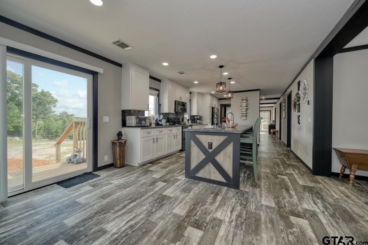 17675 Pine Drive Lindale, TX 75771 - Photo 4 of 35 a open kitchen with stainless steel appliances granite countertop a refrigerator a stove top oven and a sink with cabinets