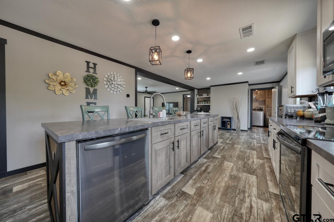 17675 Pine Drive Lindale, TX 75771 - Photo 6 of 35 a kitchen with stainless steel appliances granite countertop a lot of counter space and a sink