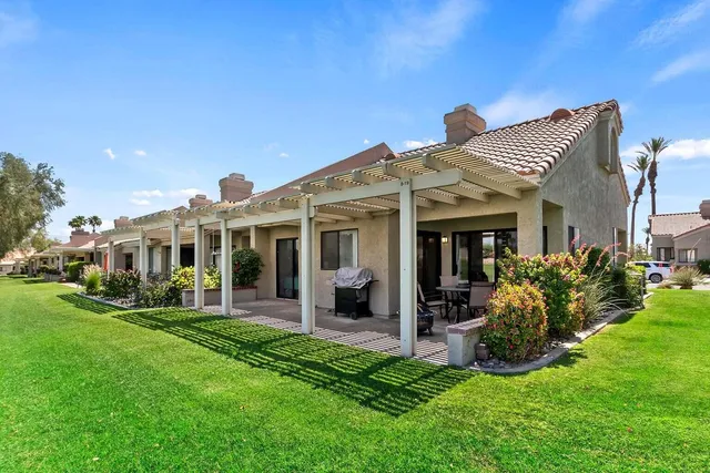 a view of a house with a yard and sitting area