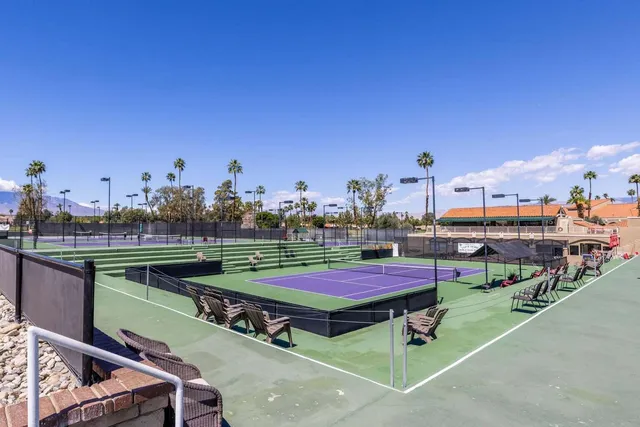 a view of a tennis ground with sitting area