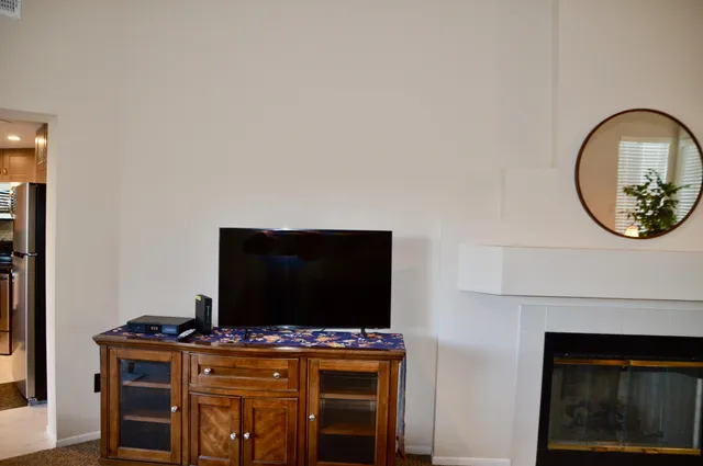 a living room with a fireplace and a flat screen tv