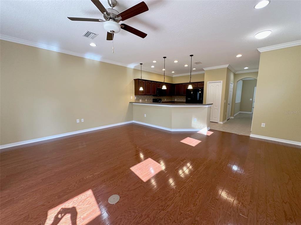 11801 Essington Street New Port Richey, FL 34654 - Photo 21 of 79 a view of a room with a ceiling fan and wooden floor