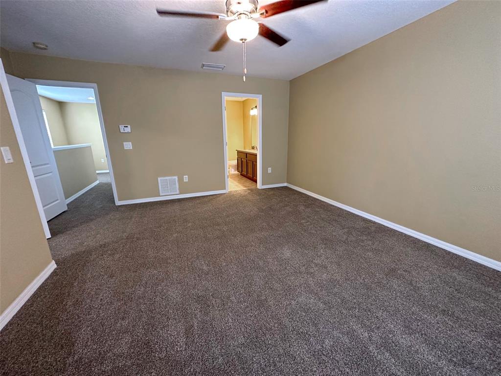 11801 Essington Street New Port Richey, FL 34654 - Photo 27 of 79 an empty room with a chandelier fan and windows