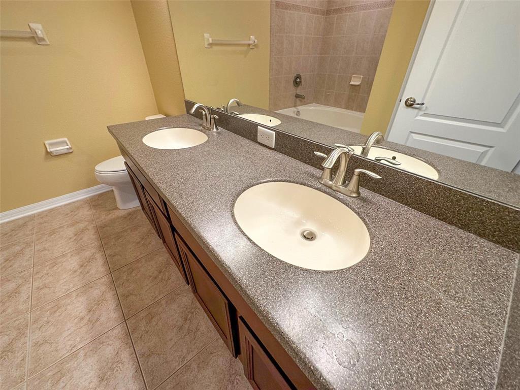 11801 Essington Street New Port Richey, FL 34654 - Photo 28 of 79 a bathroom with a granite countertop sink a mirror and a toilet