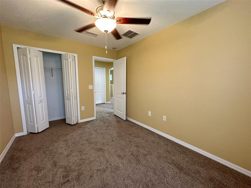 11801 Essington Street New Port Richey, FL 34654 - Photo 44 of 79 an empty room with a ceiling fan and a fan