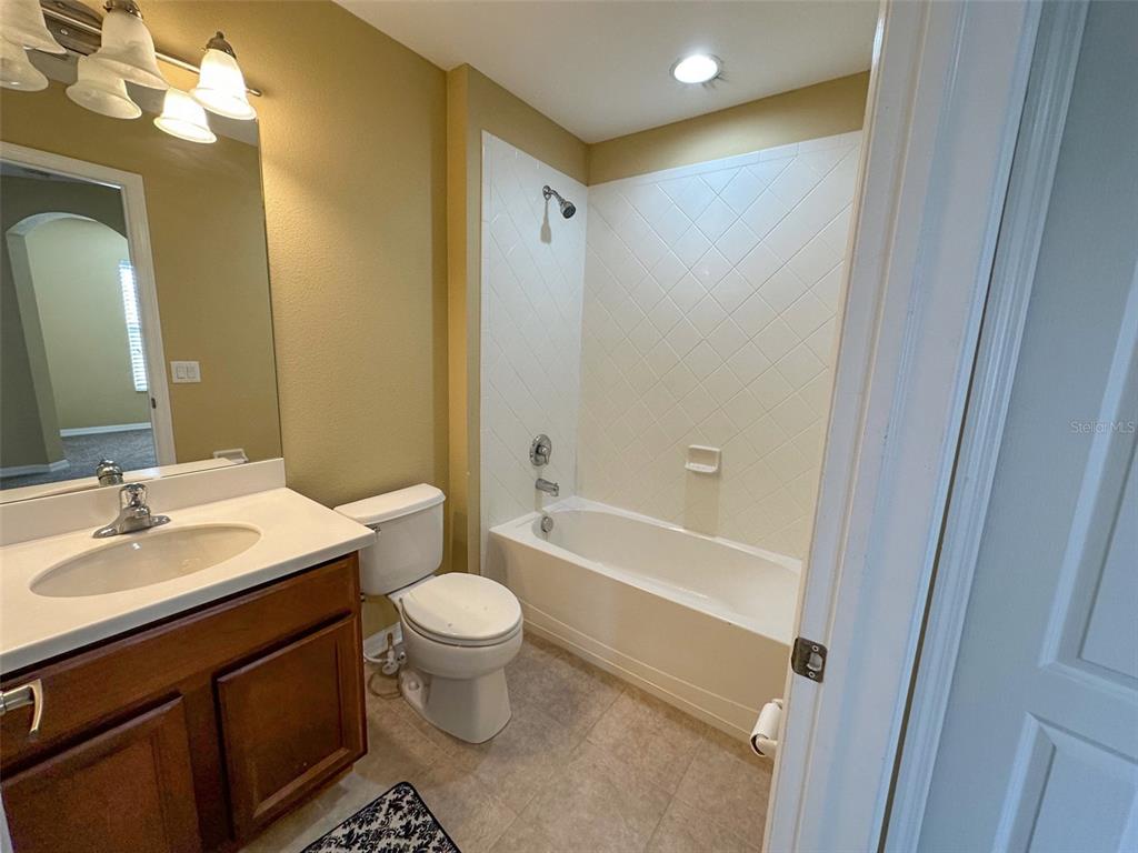 11801 Essington Street New Port Richey, FL 34654 - Photo 46 of 79 a bathroom with a sink a toilet a mirror a vanity and shower