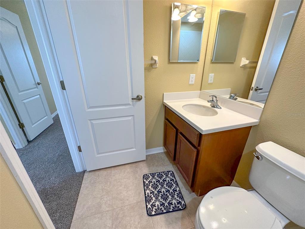 11801 Essington Street New Port Richey, FL 34654 - Photo 48 of 79 a bathroom with a sink a toilet a mirror and vanity