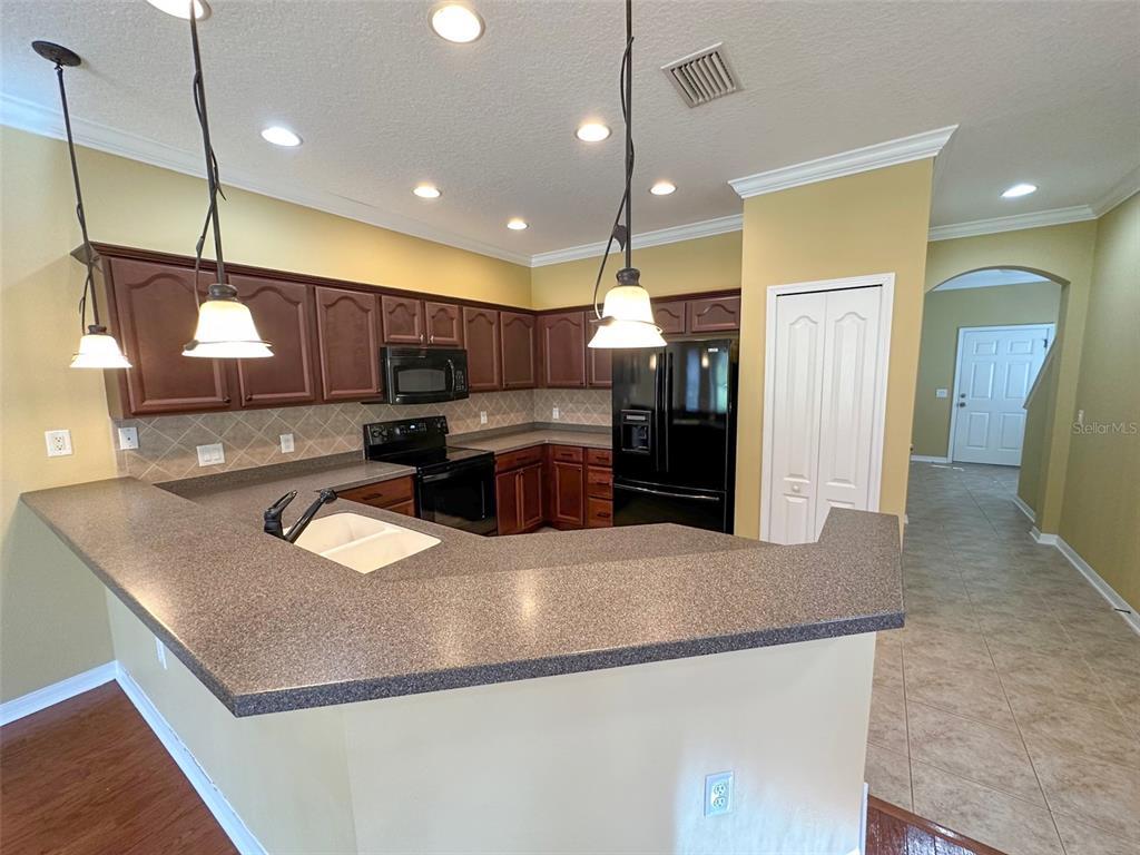 11801 Essington Street New Port Richey, FL 34654 - Photo 6 of 79 a kitchen with kitchen island a sink stainless steel appliances and a counter top