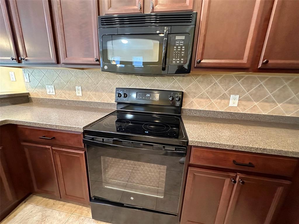11801 Essington Street New Port Richey, FL 34654 - Photo 9 of 79 a kitchen with wooden cabinets and a stove top oven