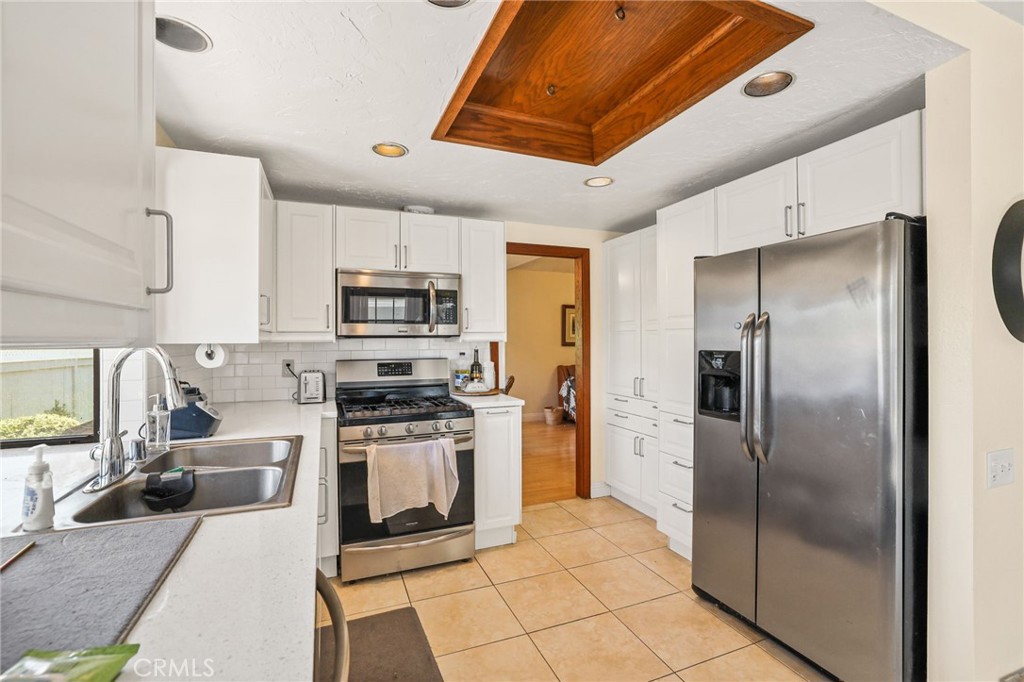 14 Thunder Trail, Unit 28 Irvine, CA 92614 - Photo 14 of 60 a kitchen with stainless steel appliances granite countertop a refrigerator a stove and a sink with wooden floor