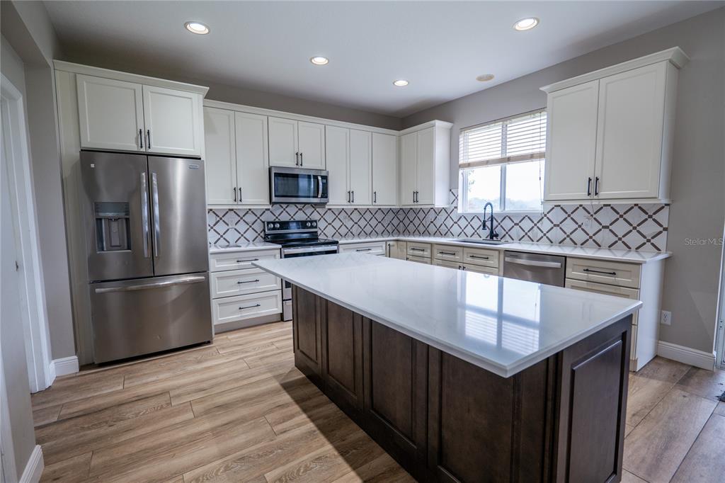 852 North Jacks Lake Road Clermont, FL 34711 - Photo 9 of 29 a kitchen with stainless steel appliances granite countertop a refrigerator a stove a sink and a microwave