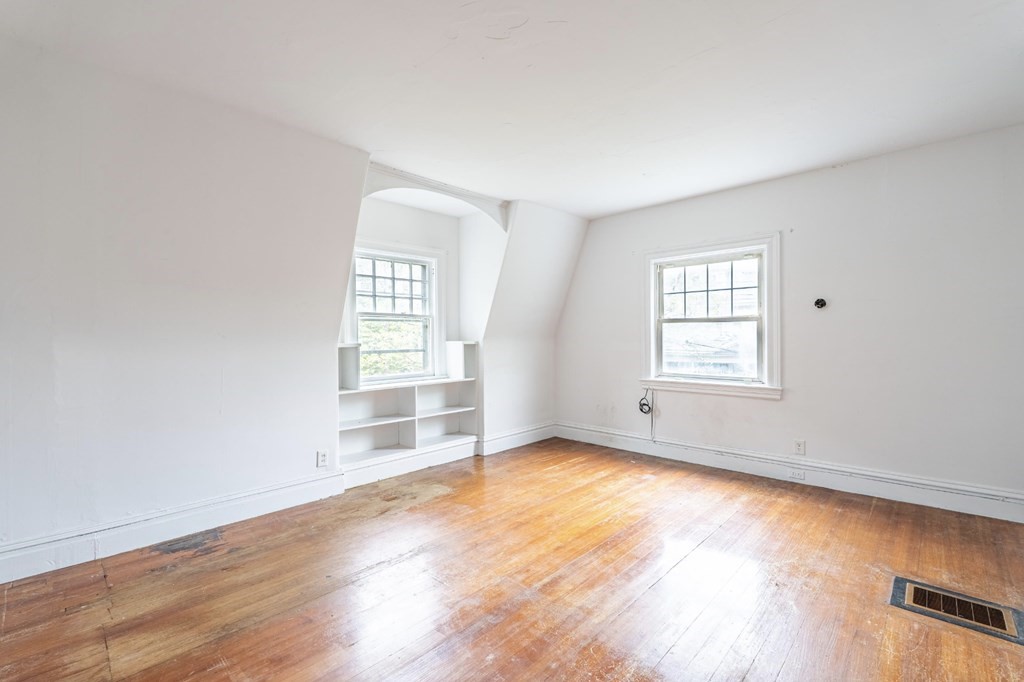 85 Naples Road Brookline, MA 02446 - Photo 12 of 19 an empty room with wooden floor and windows