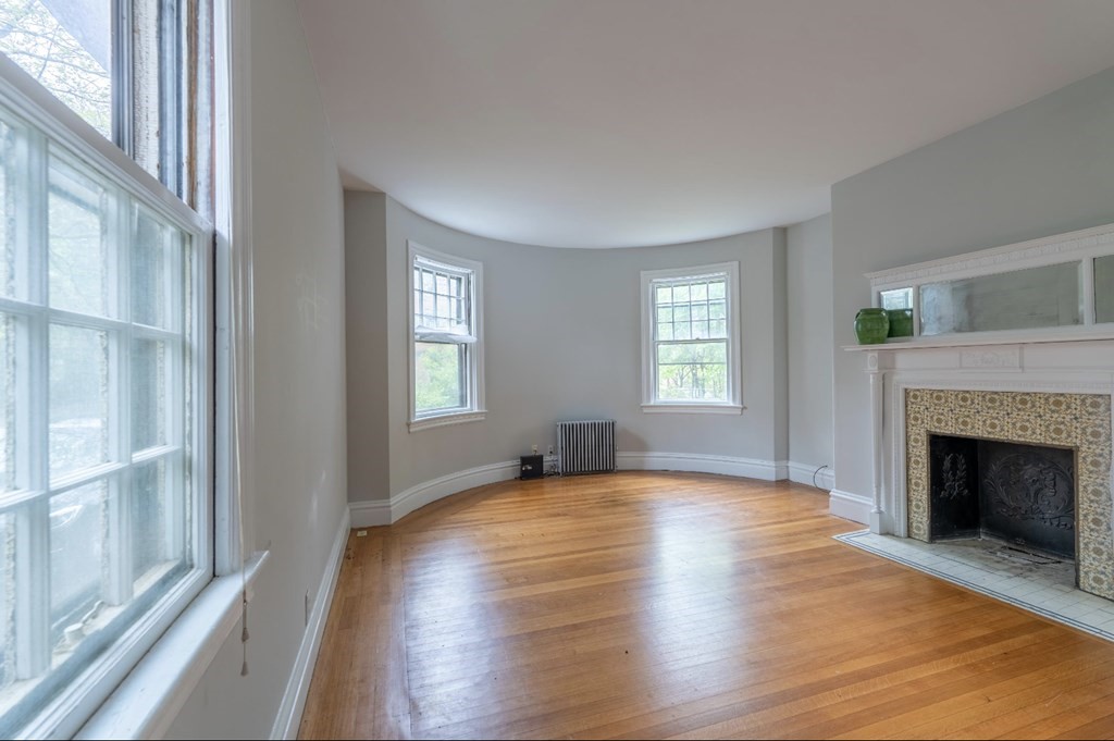 85 Naples Road Brookline, MA 02446 - Photo 4 of 19 a view of an empty room with wooden floor and a window