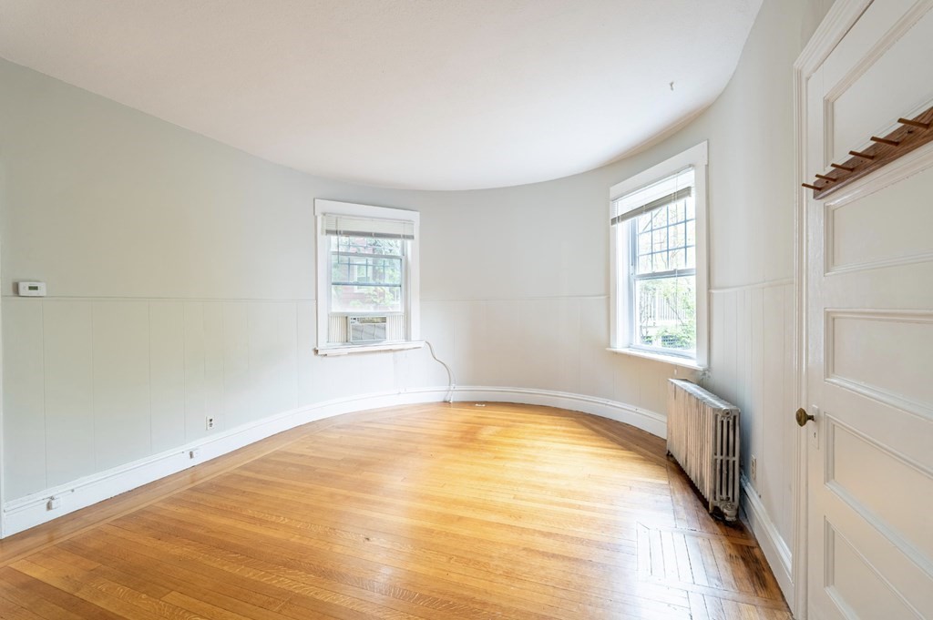 85 Naples Road Brookline, MA 02446 - Photo 8 of 19 a view of an empty room with wooden floor and a window