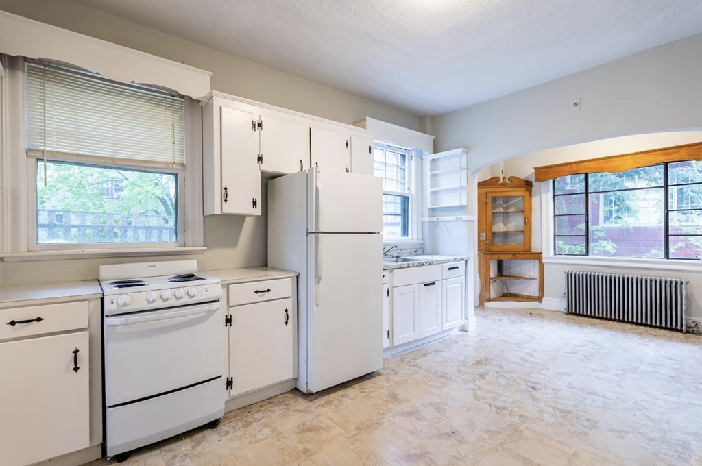 85 Naples Road Brookline, MA 02446 - Photo 9 of 19 a kitchen with white cabinets and white appliances