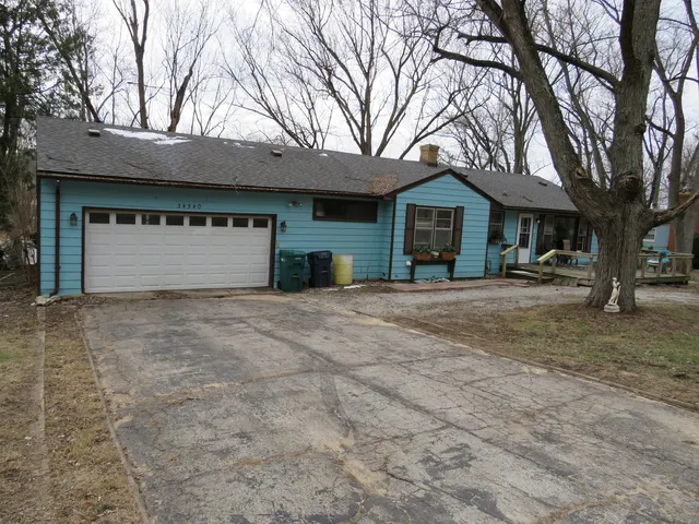 a view of a house with a yard and large tree