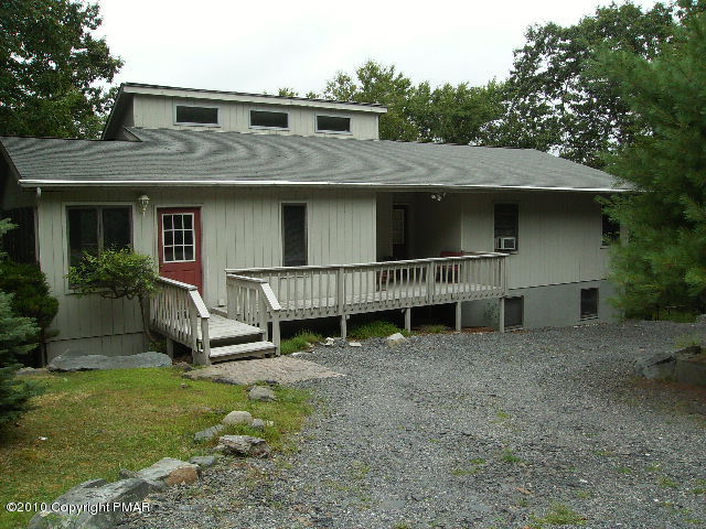 a view of a house with a yard and sitting area