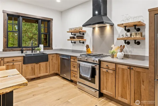 a kitchen with stainless steel appliances a stove and white cabinets