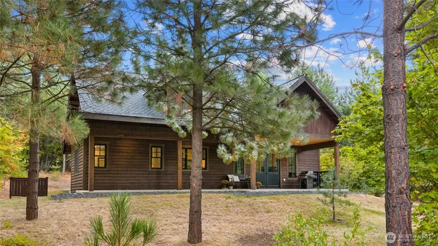 a front view of a house with a tree