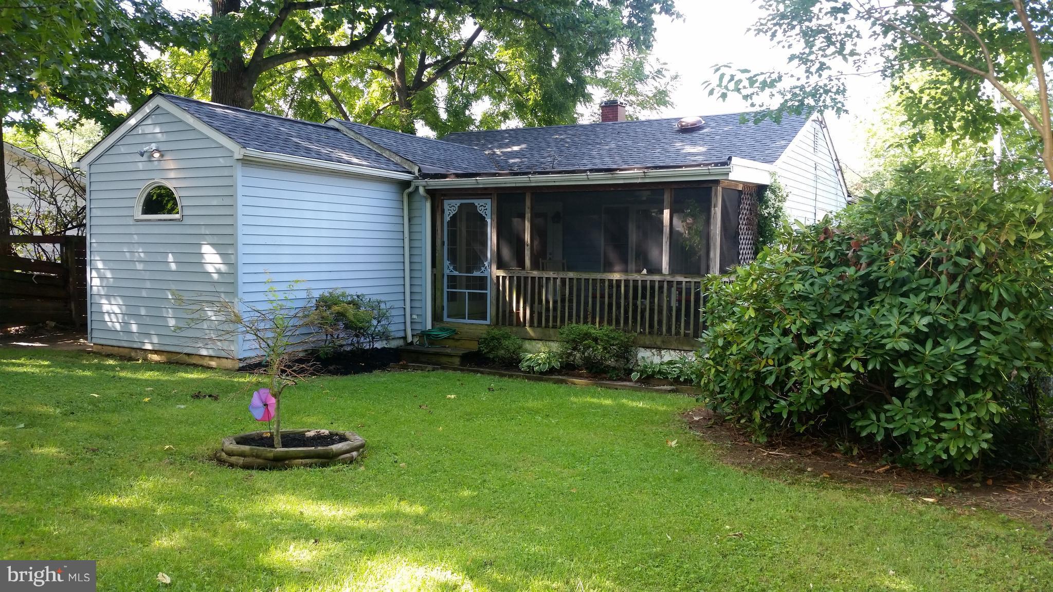 1305 4th Road Baltimore, MD 21220 - Photo 1 of 24 a backyard of a house with plants and large tree