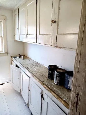 a kitchen with granite countertop white cabinets and white appliances