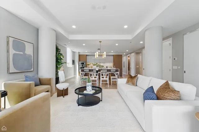 a living room with furniture and a view of kitchen